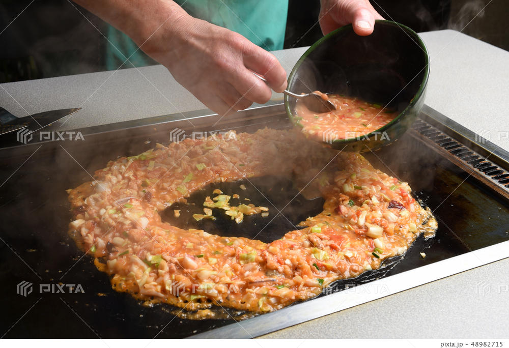 もんじゃ焼き-ゆるい生地を土手の中に流し込む